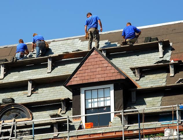 A group of men on top of a roof

Description automatically generated with medium confidence